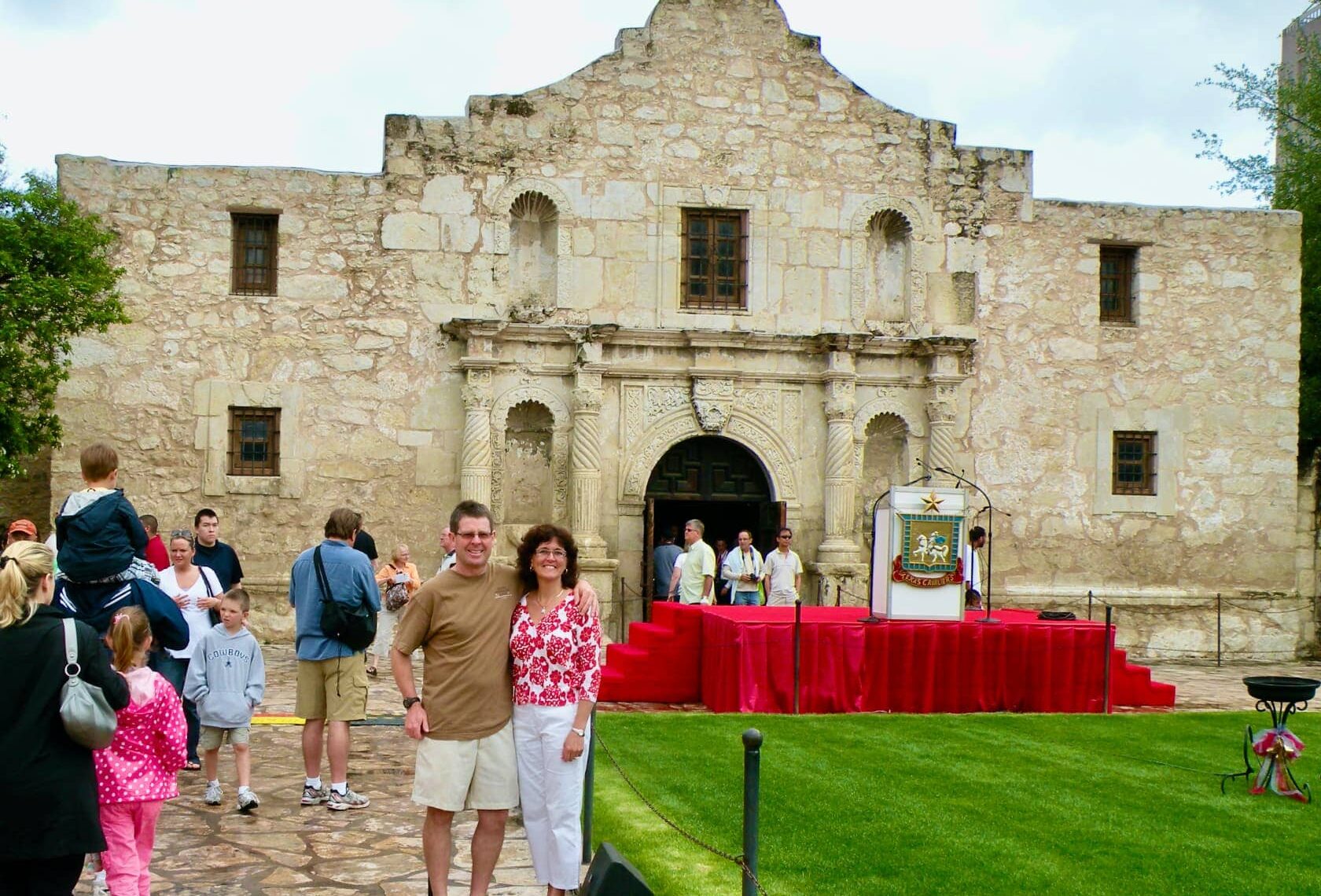 A couple standing in front of Alamo in Texas