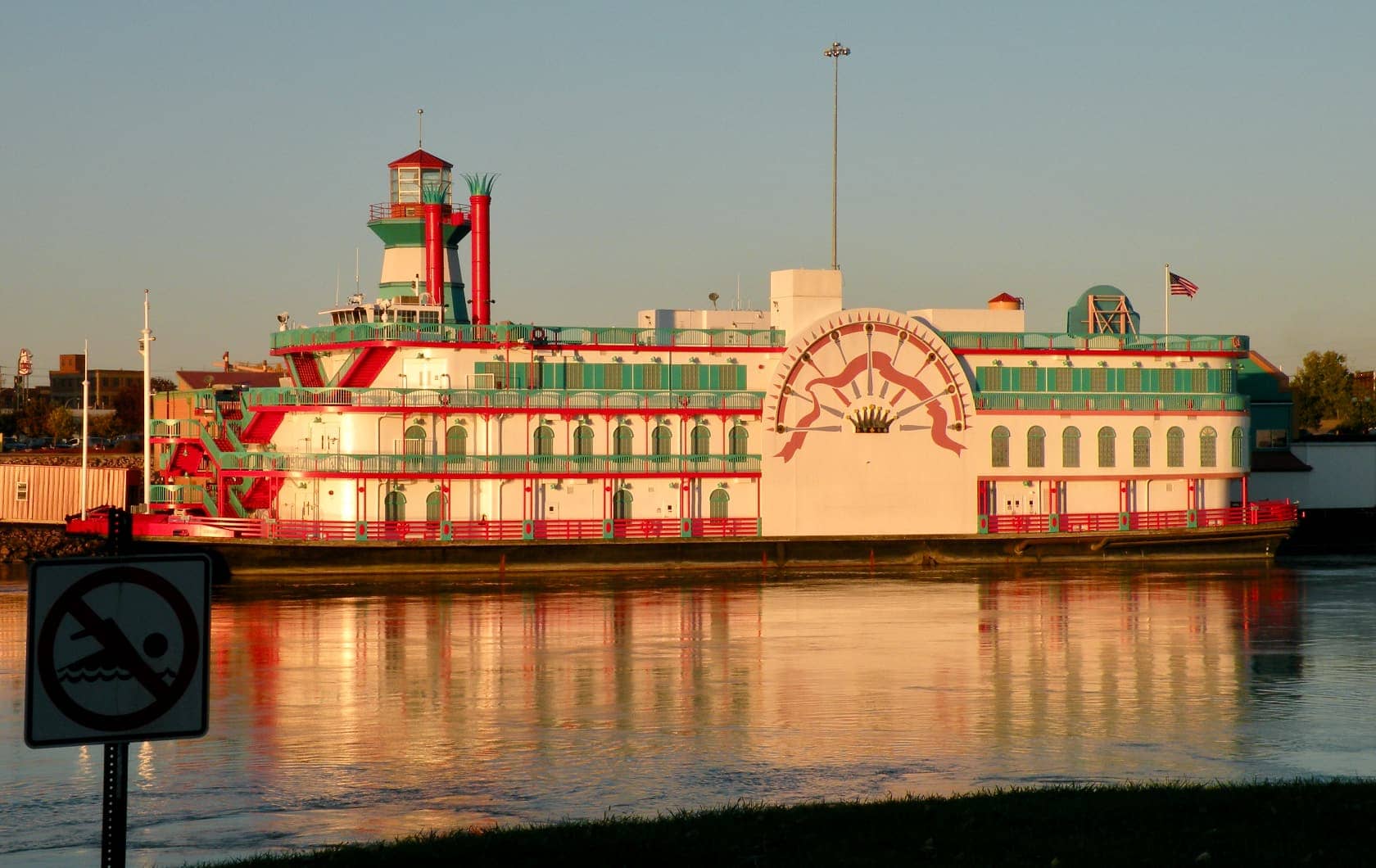 Green, red, and white paddle steamer boat
