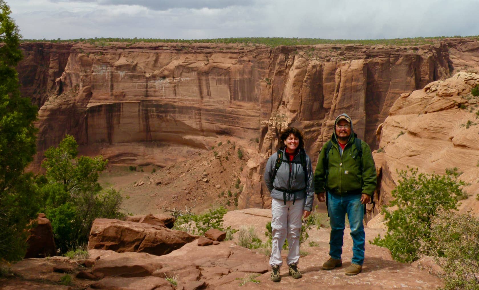 Woman and man hikers standing in front of canyon