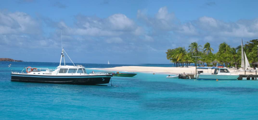 Blue and white sail boat in tropical lagoon