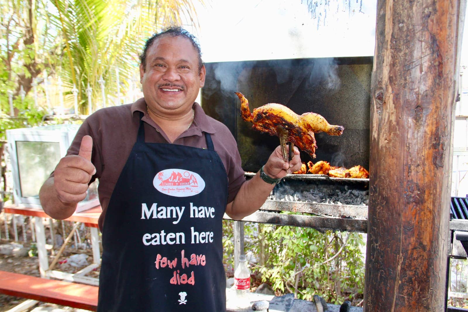 Mexican man serving grilled chicken