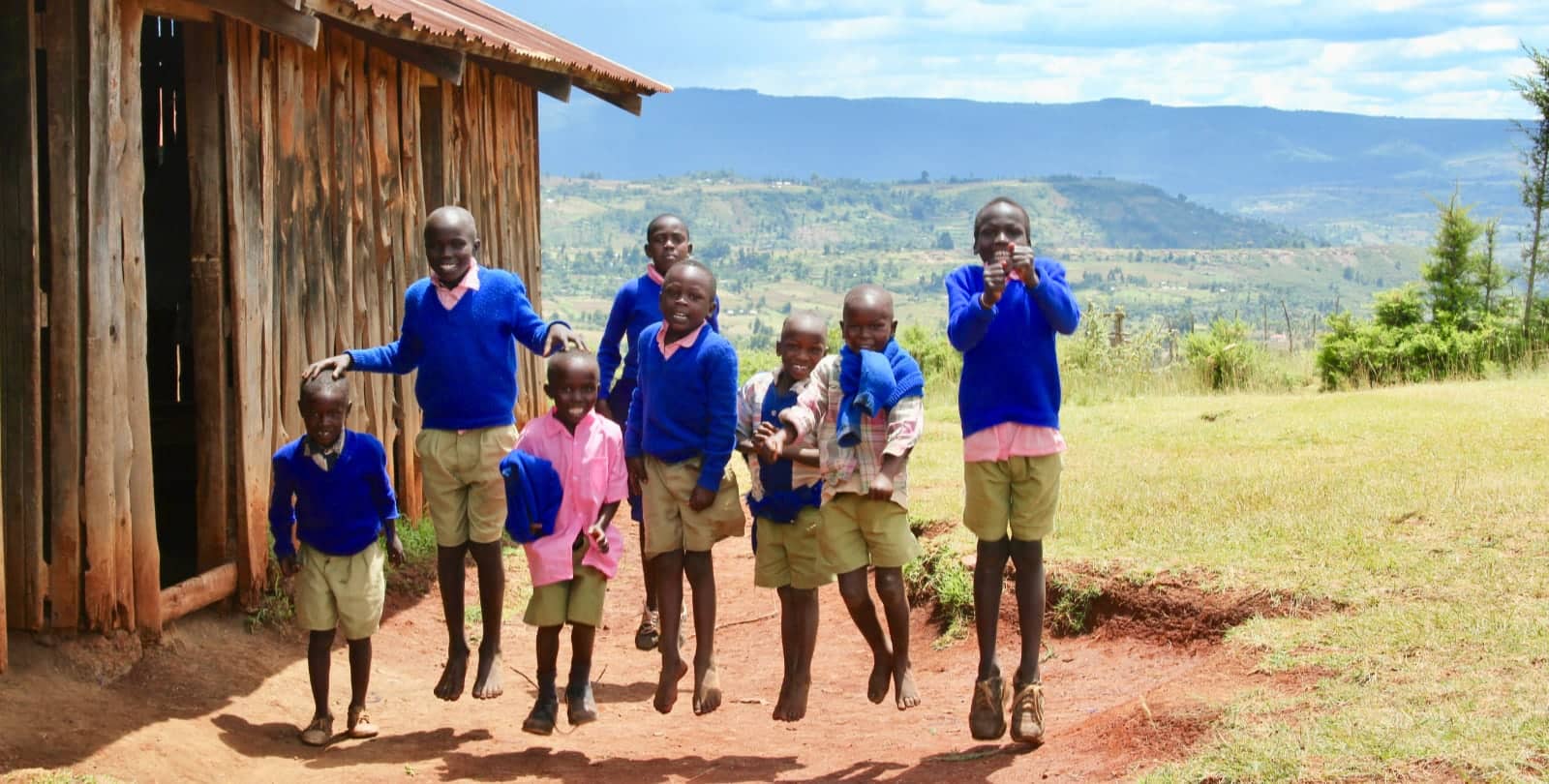 African children in blue sweaters smiling