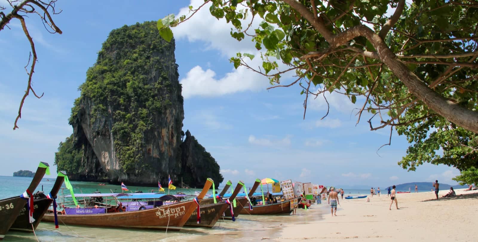 Thai tour boats parked on white sand beach