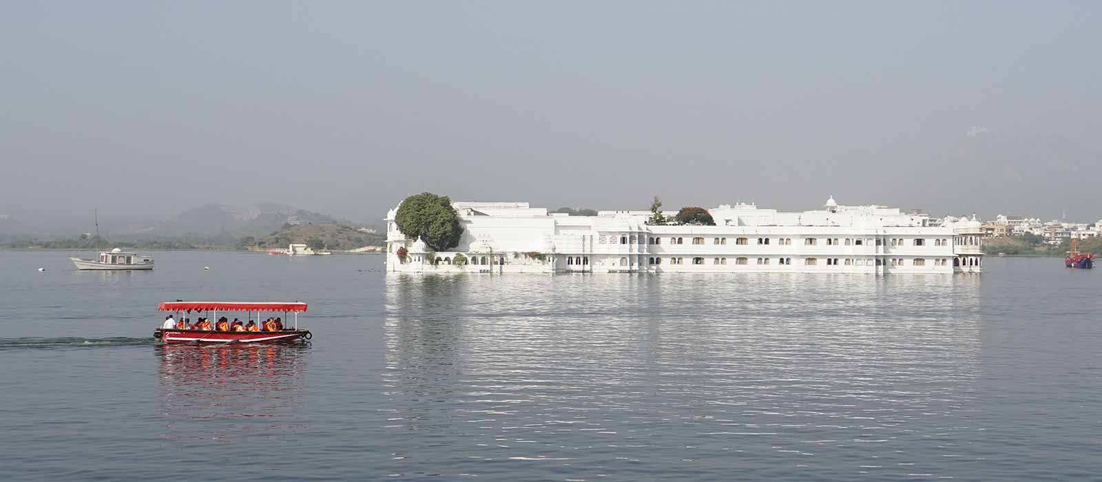 White building and red boat in river