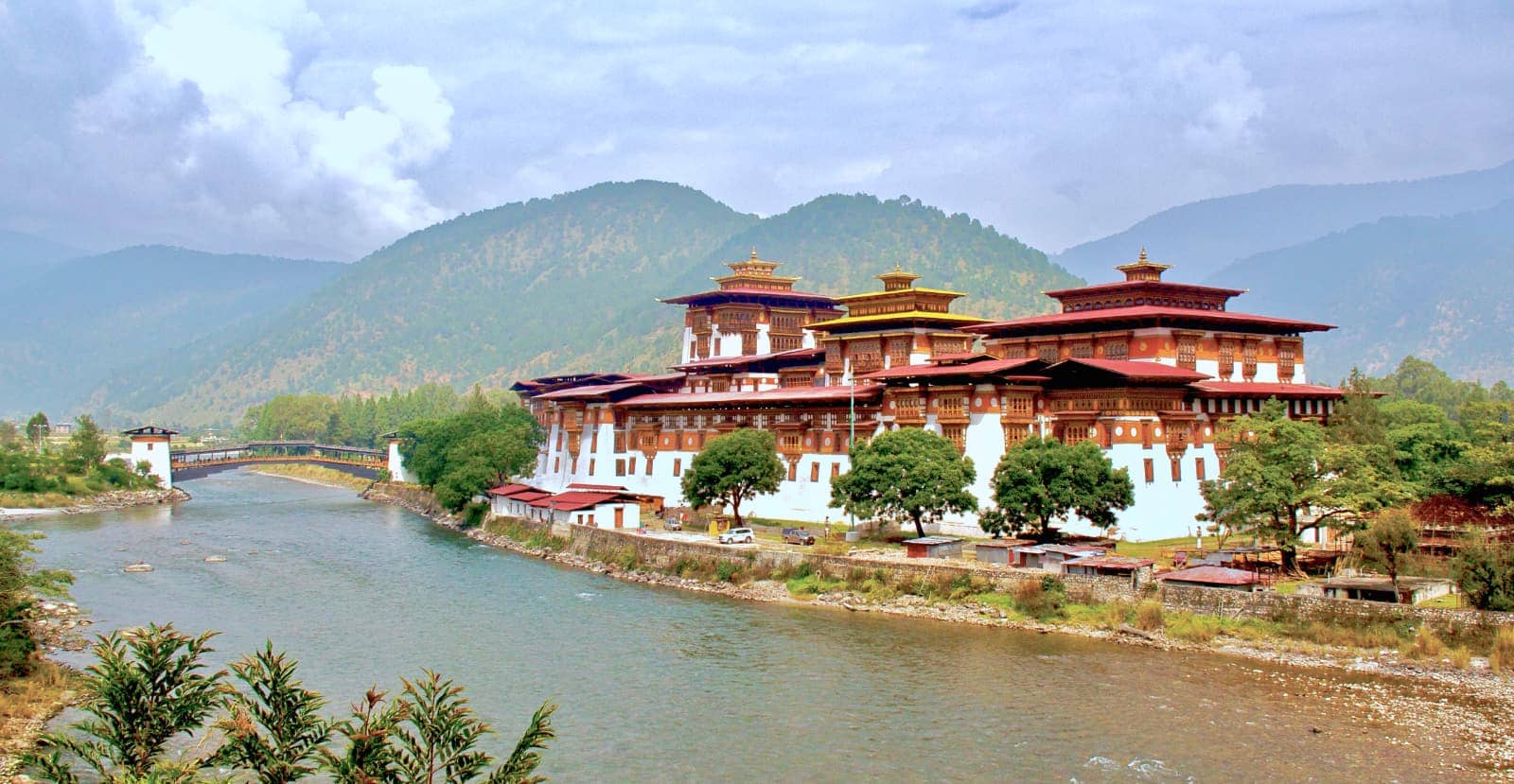Bhutanese temple and river in foreground with mountains in background