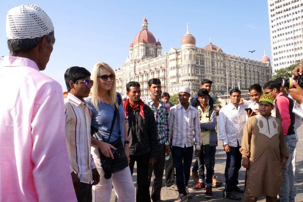 Blonde haired woman standing amongst Indian men