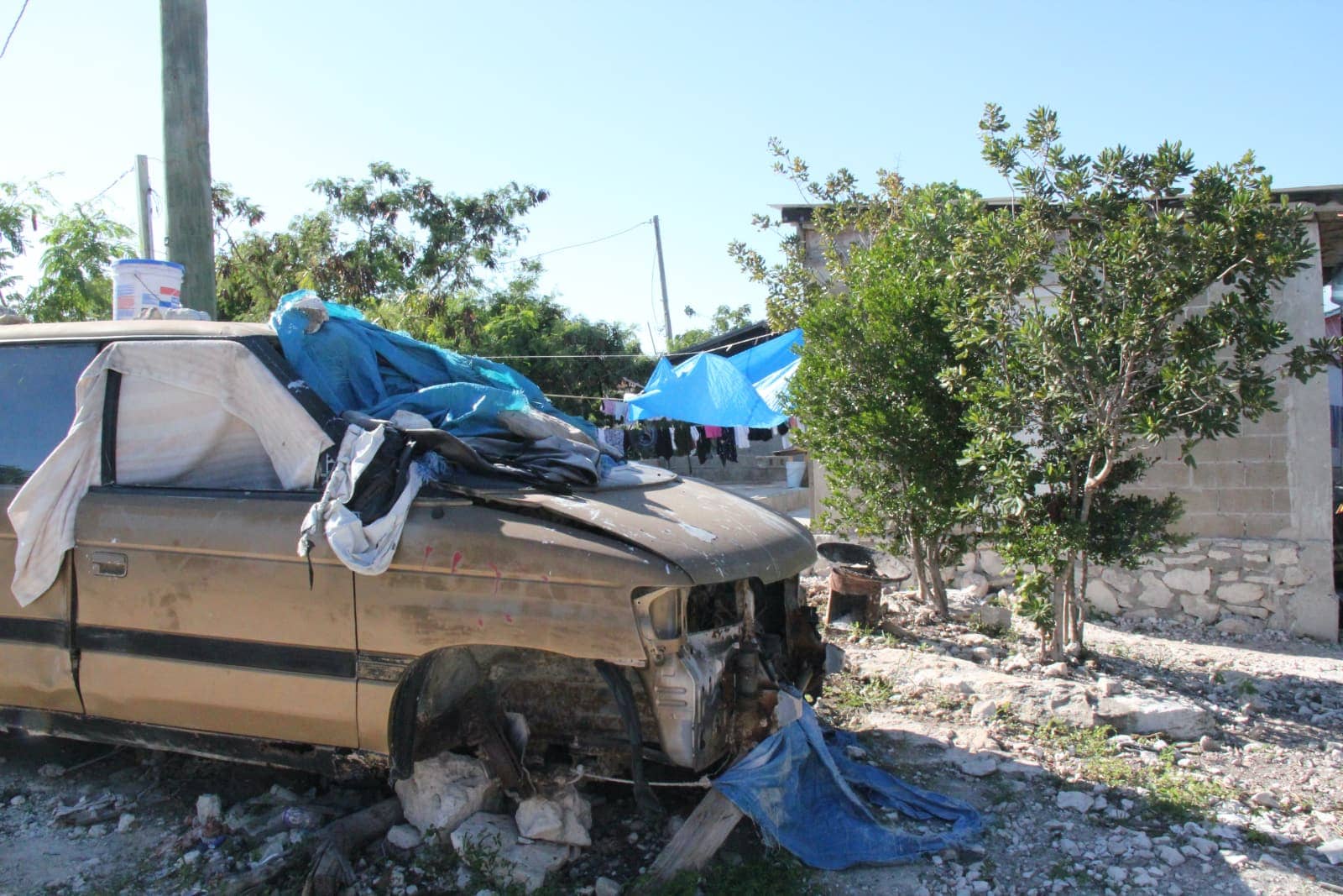 Broken down old van in foreground with stone walled home in background