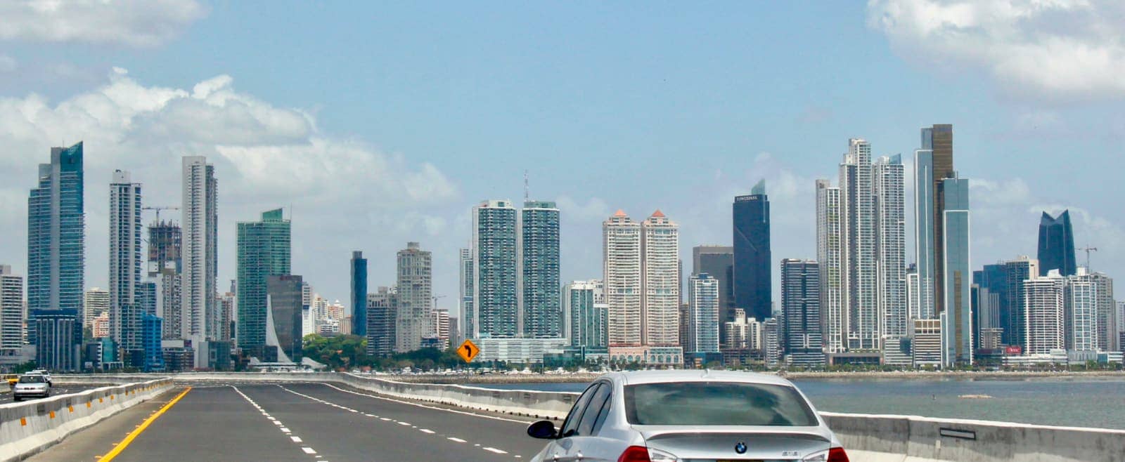 Car driving towards high rise buildings