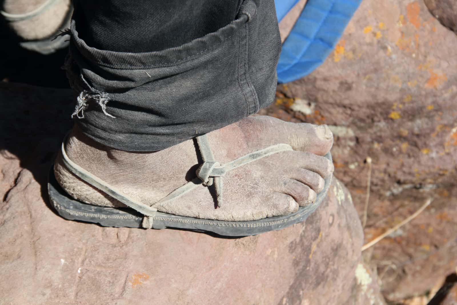 Close up of man's dusty foot in sandal