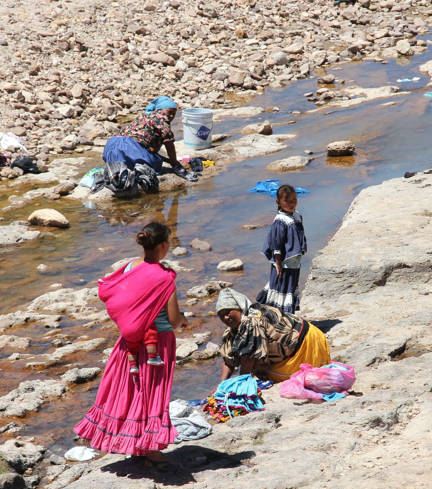 Family washing clothes in river