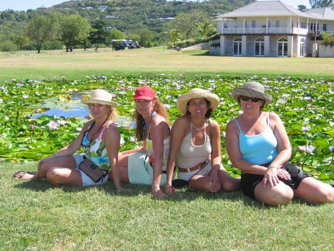 Four women kneeling on green grass