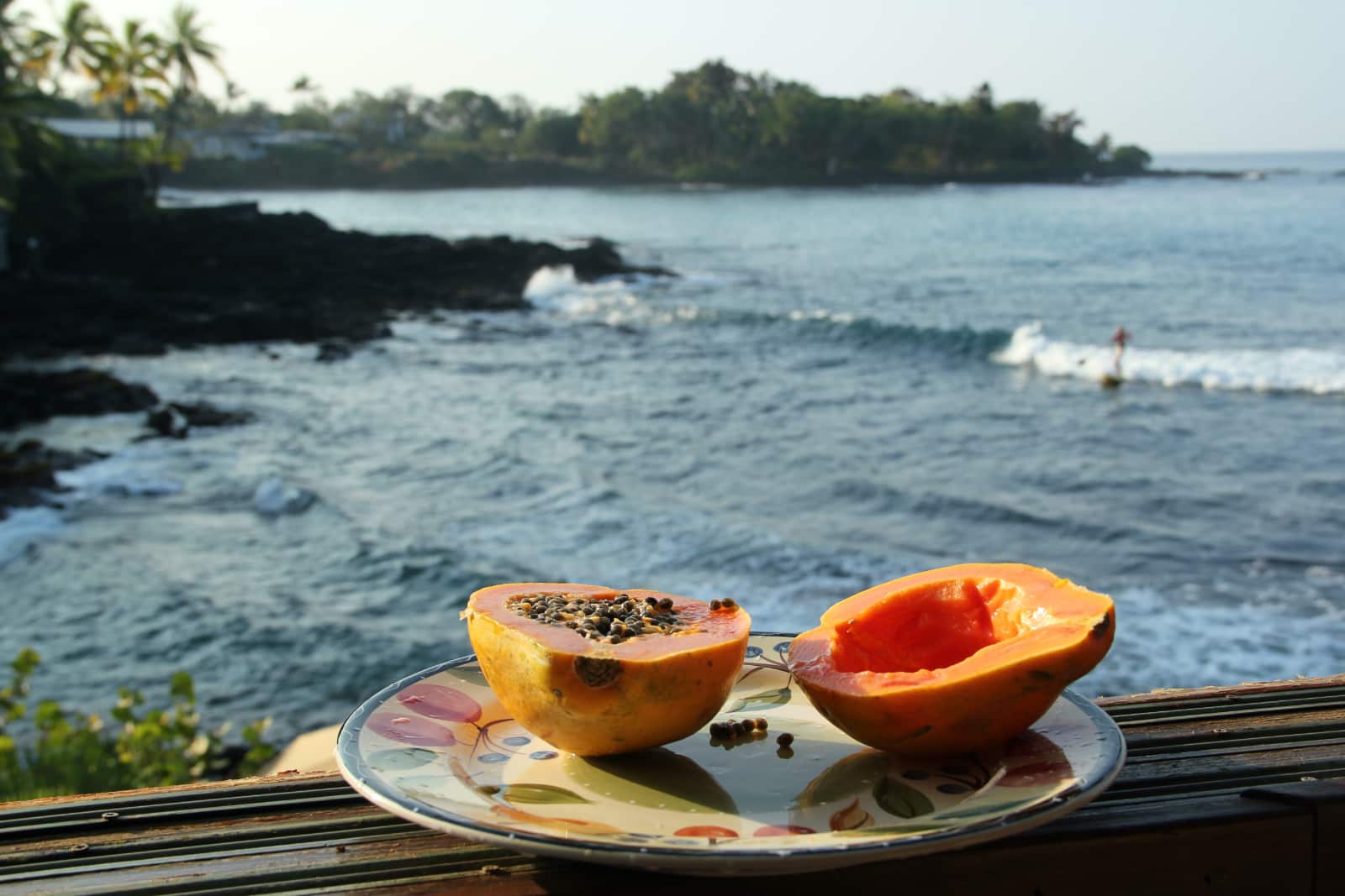 Fresh orange papaya on plate with ocean in background