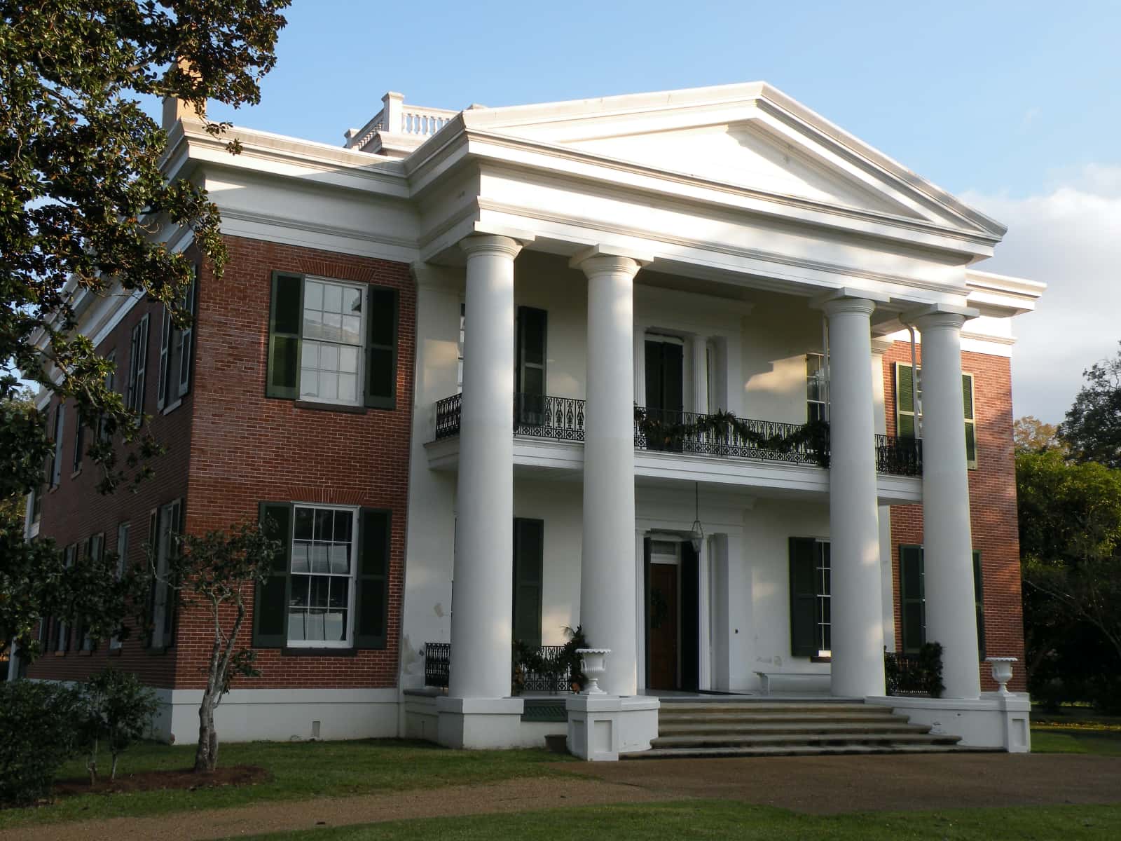 Front view of old red brick house with white columns