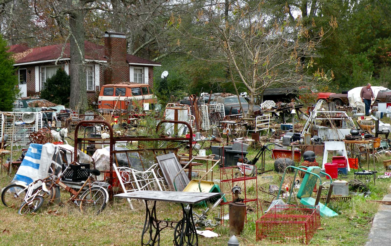 Yard filled with tables, chairs, and bicycles