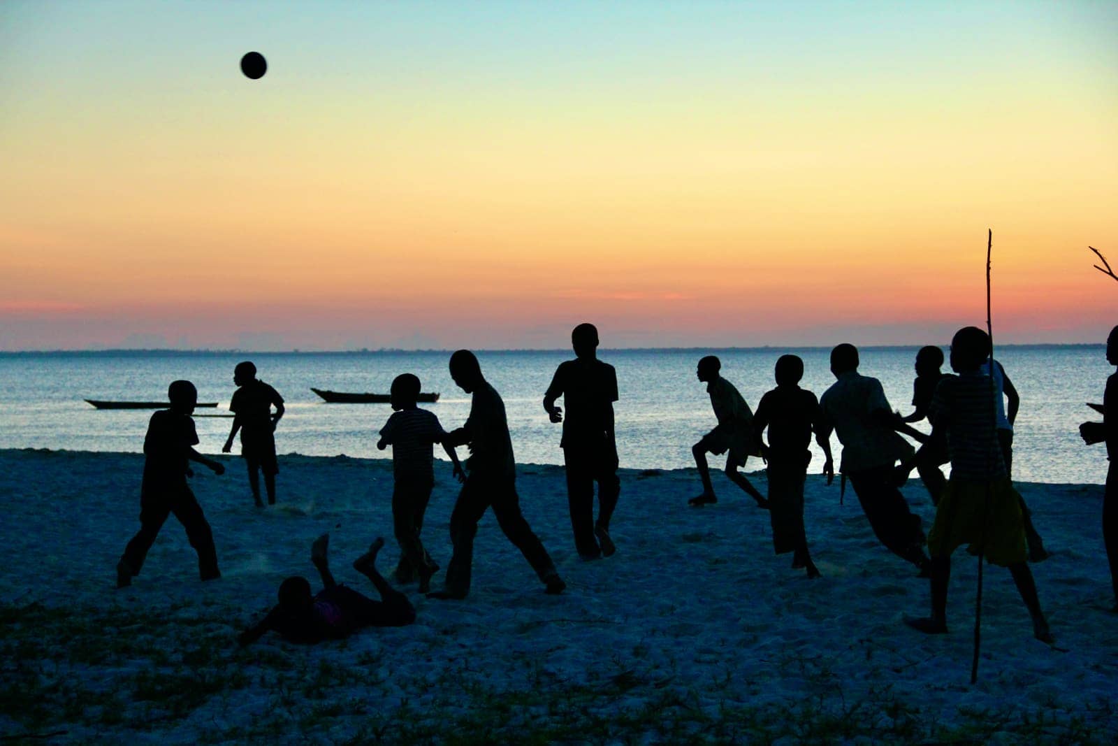 Group of children playing a game on beach at sunset