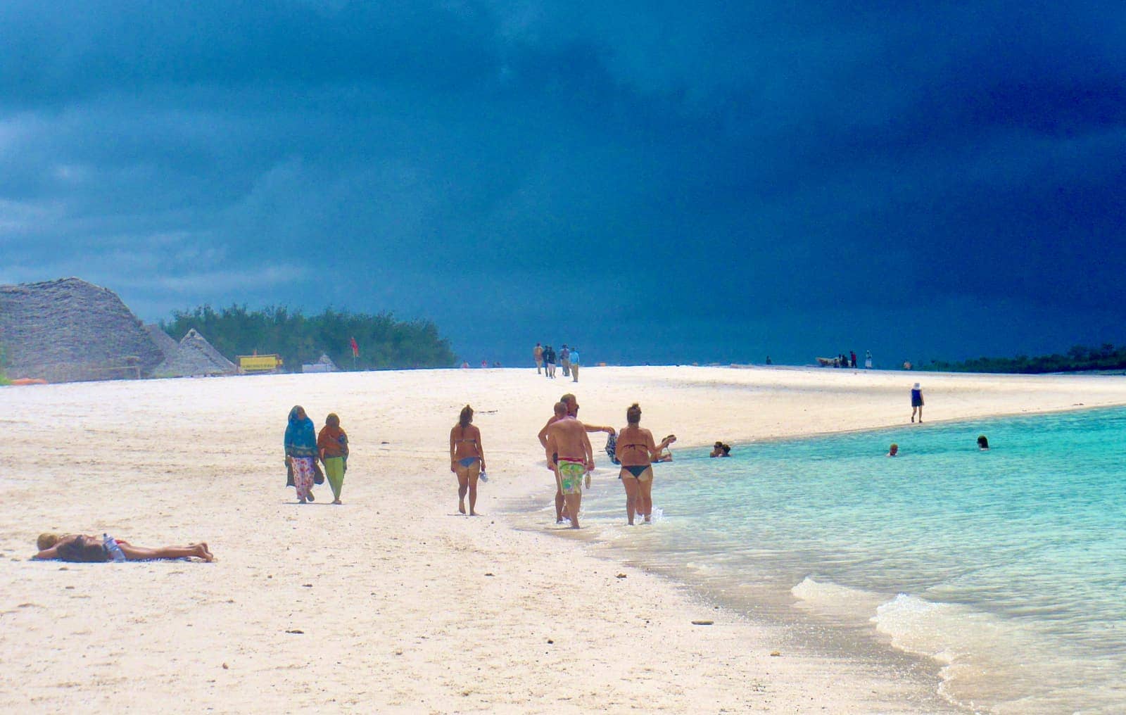 Group of people enjoying white sand beach and turquoise ocean