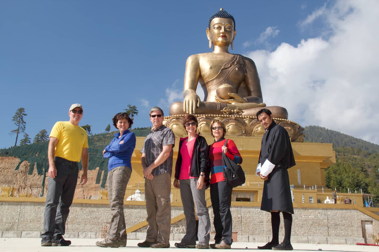 Group of people posing in front of giant Buddha statue