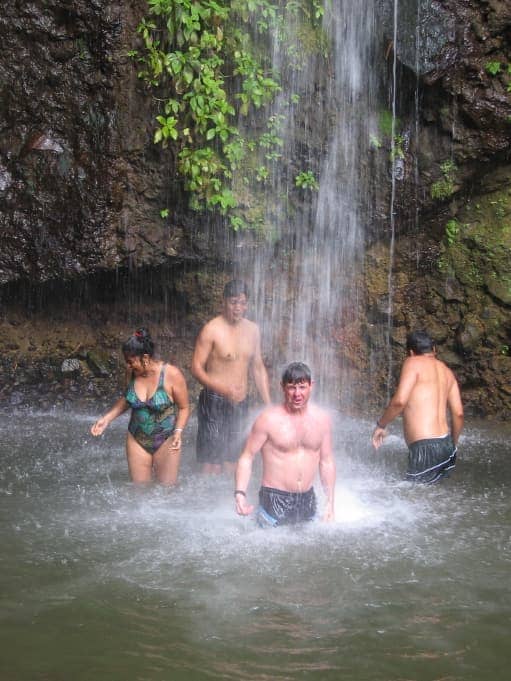 Group of people standing under waterfall