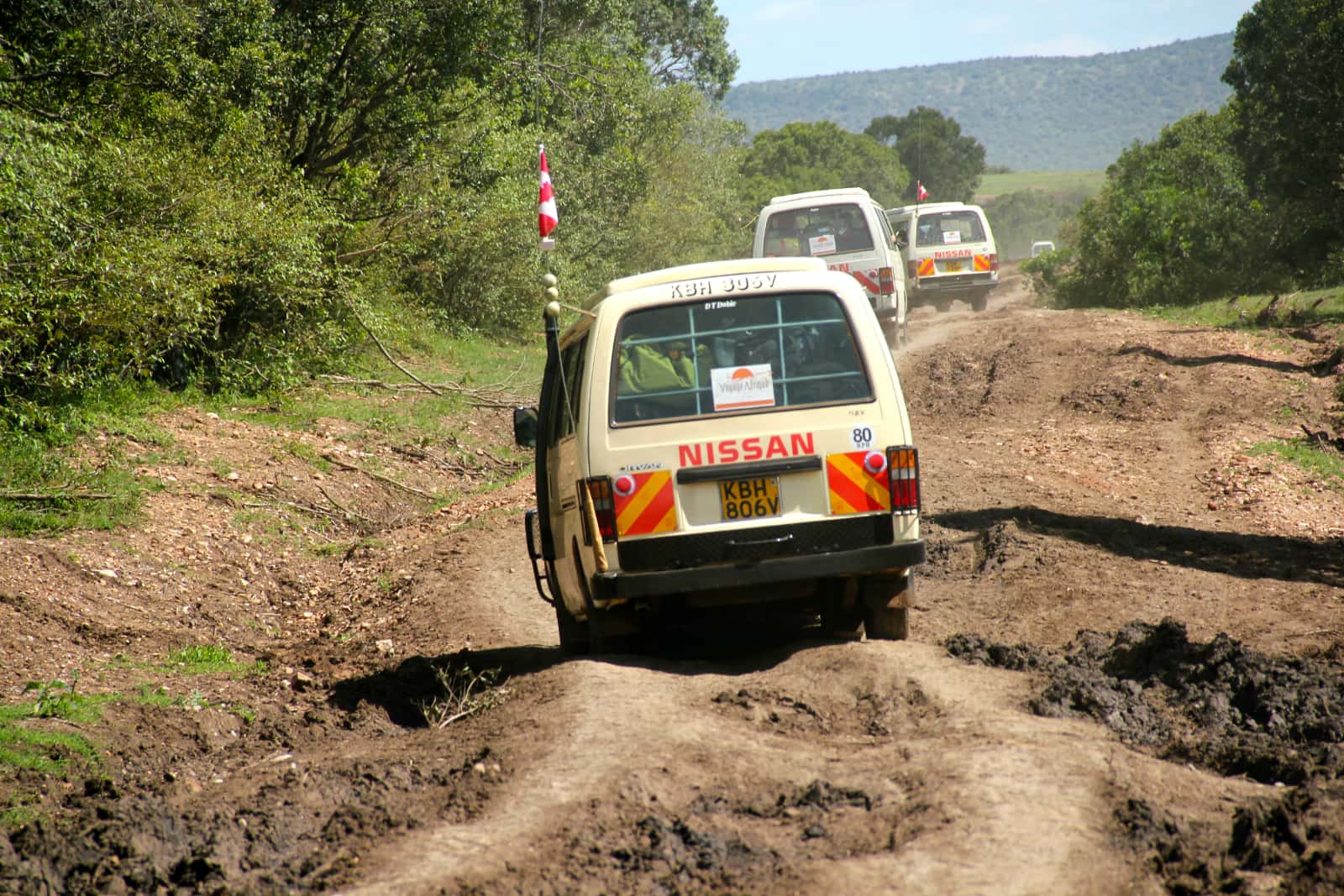 Group of vans driving over uneven terrain