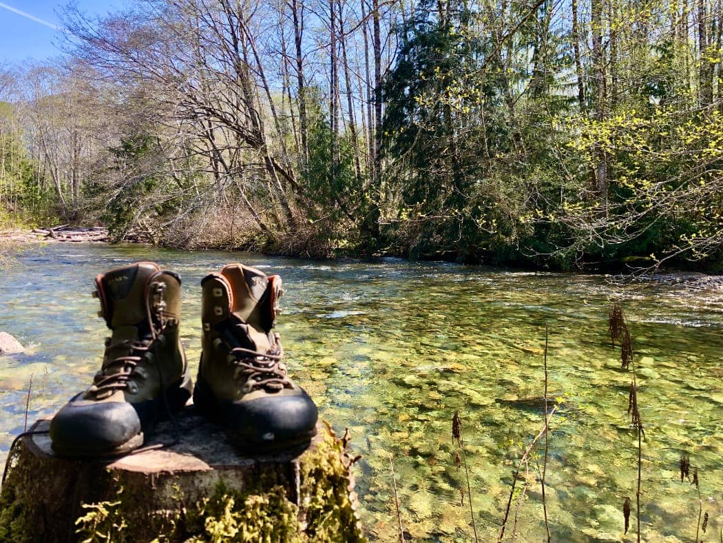 Hiking boots sitting next to river