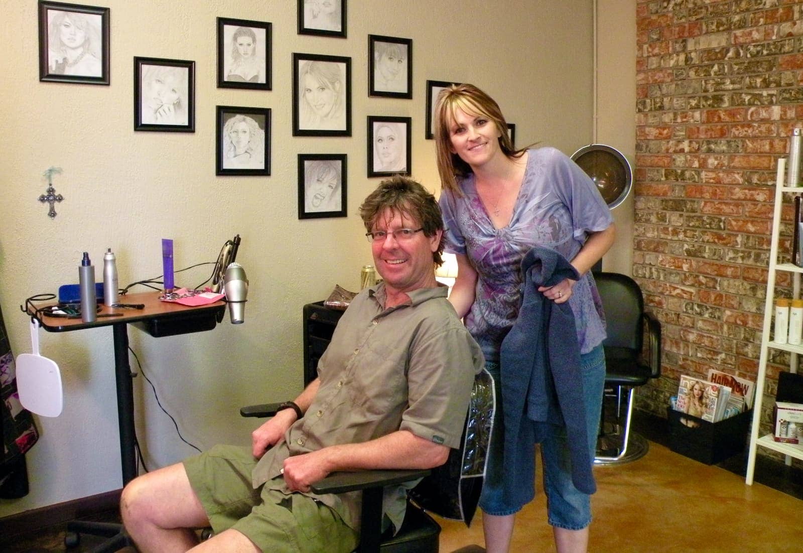 Man receiving a hair cut from a woman