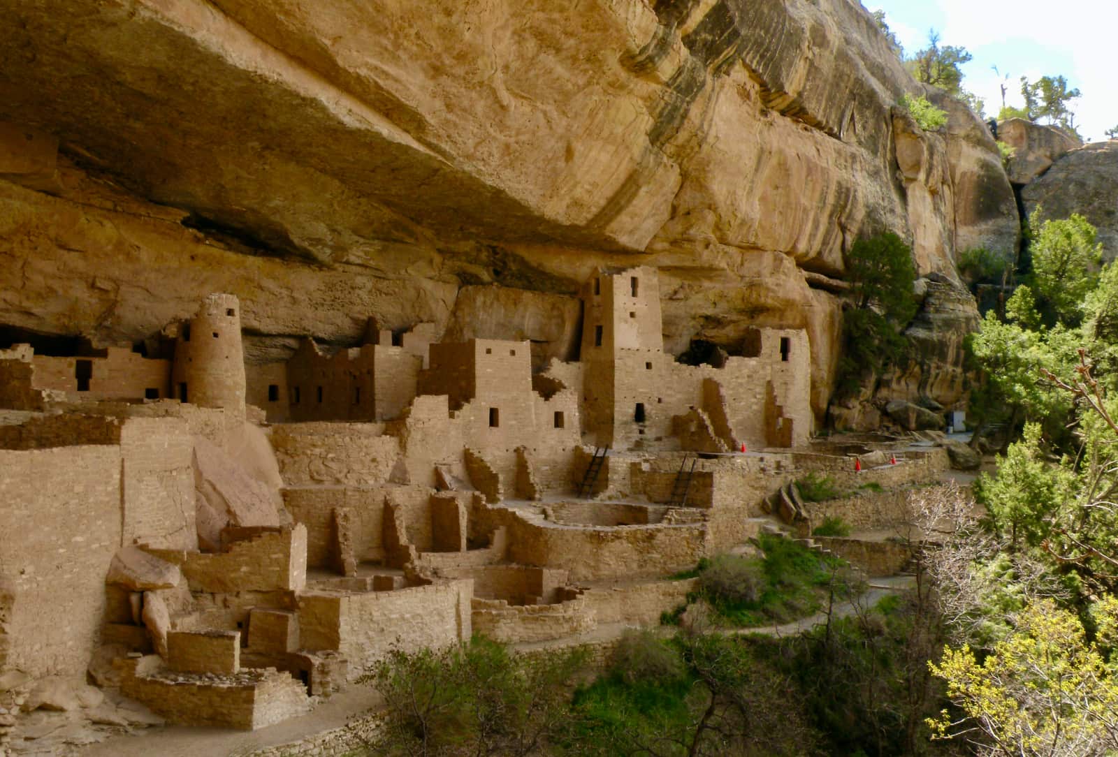 Indigenous stone buildings built under rock face