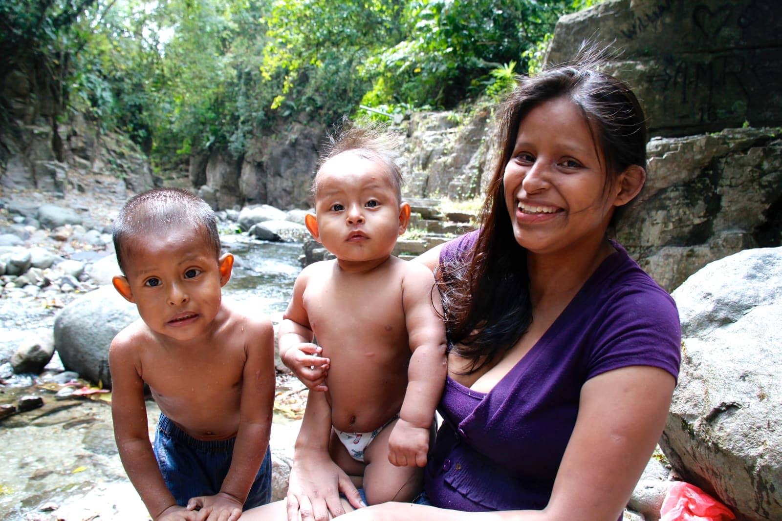 Indigenous woman and children smiling at camera