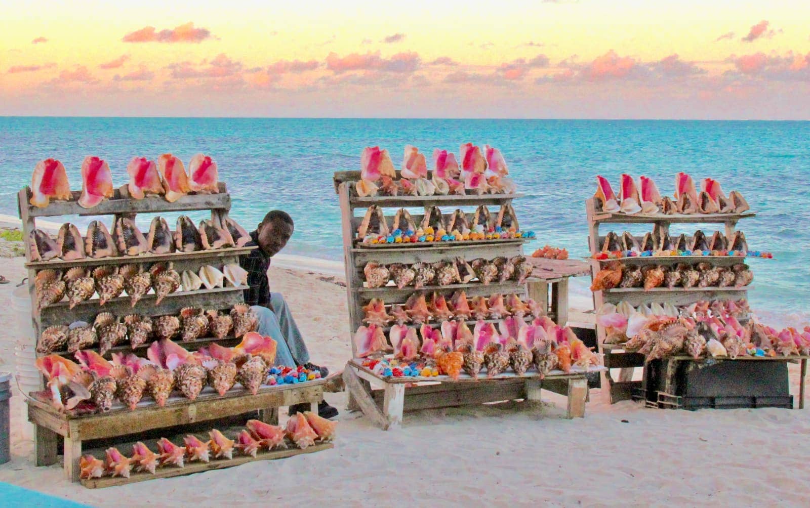 Local man selling colourful conches on beach