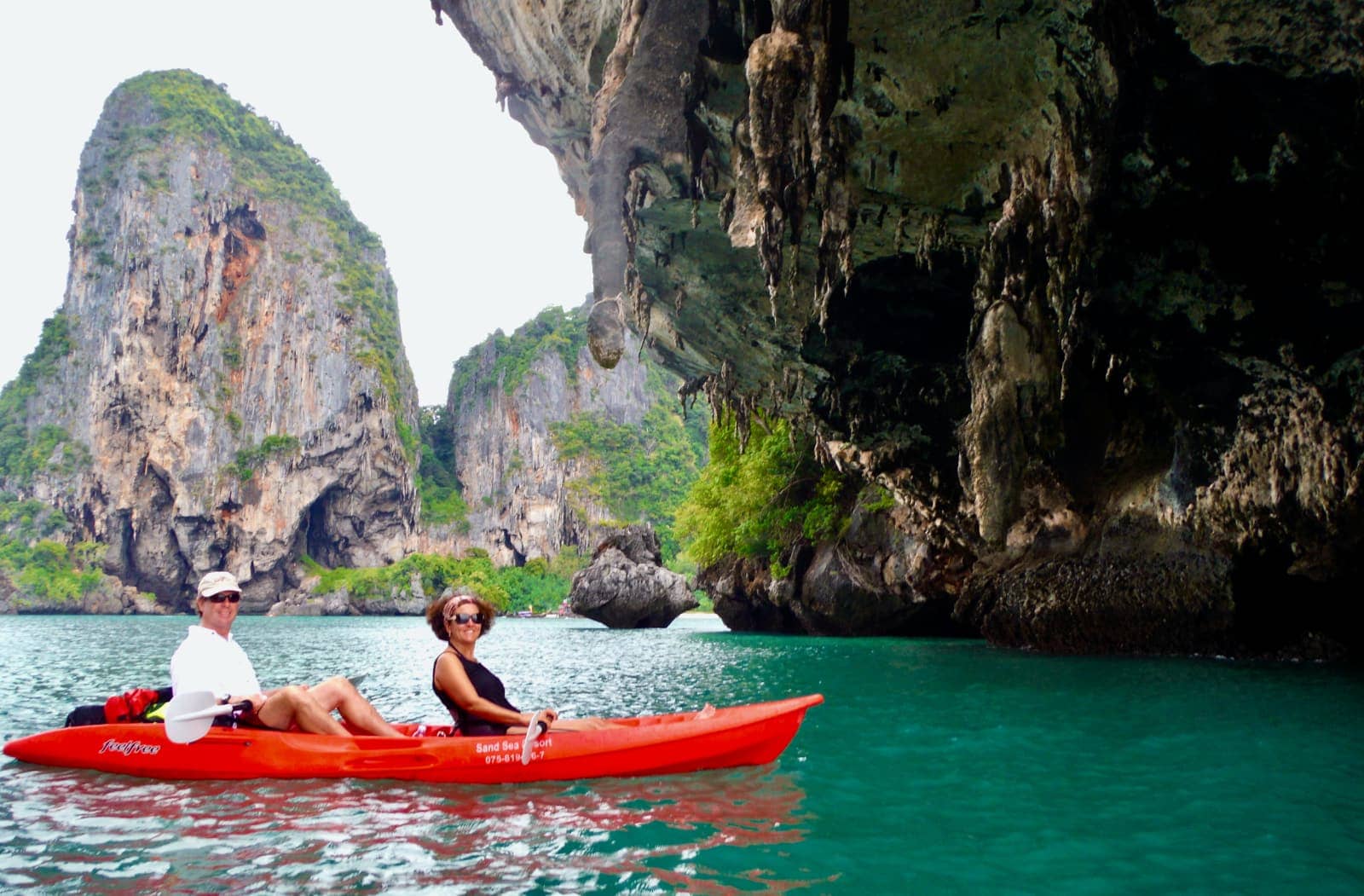 Man and woman kayaking amongst rocks in ocean