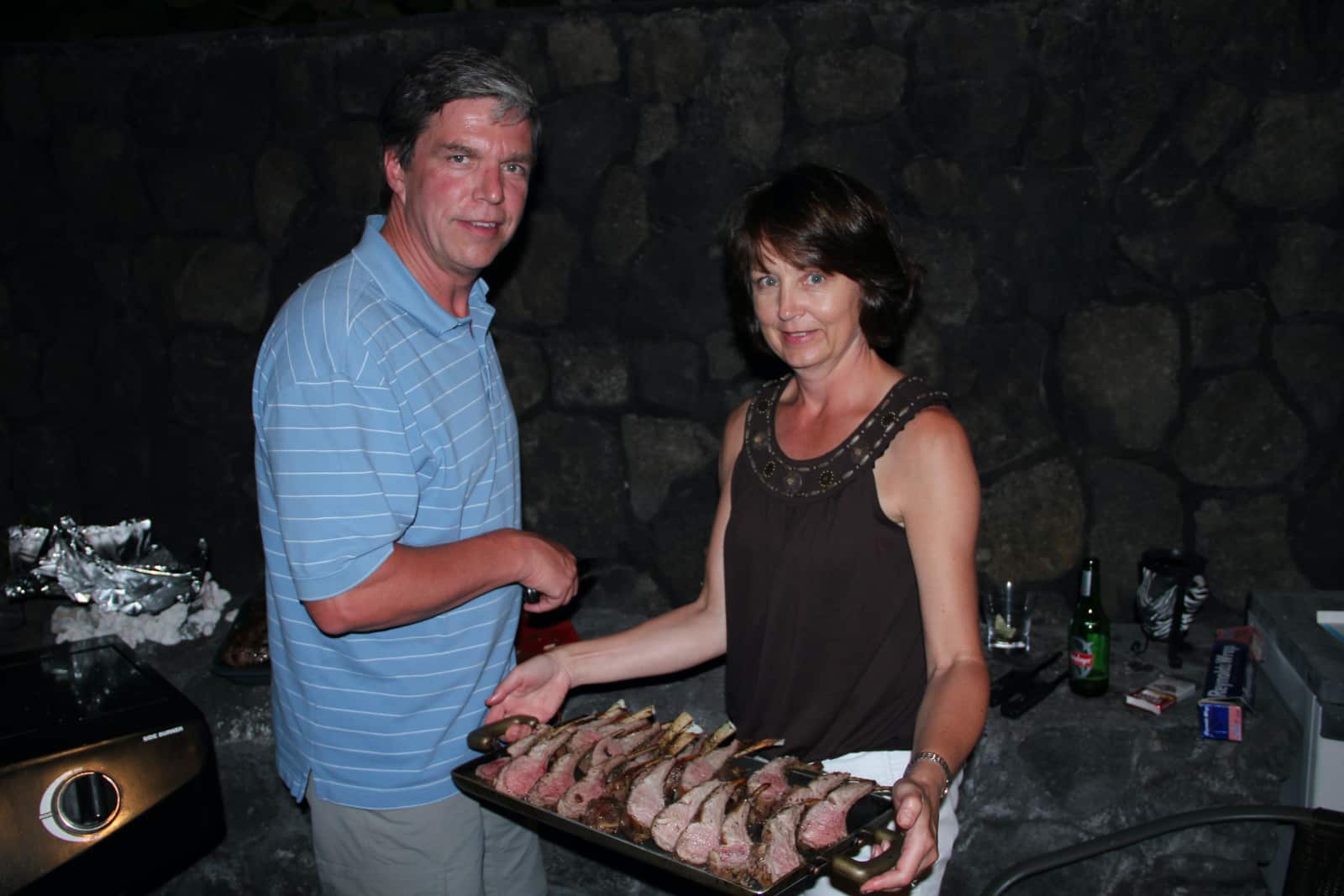 Man and woman posing with plate of red meat