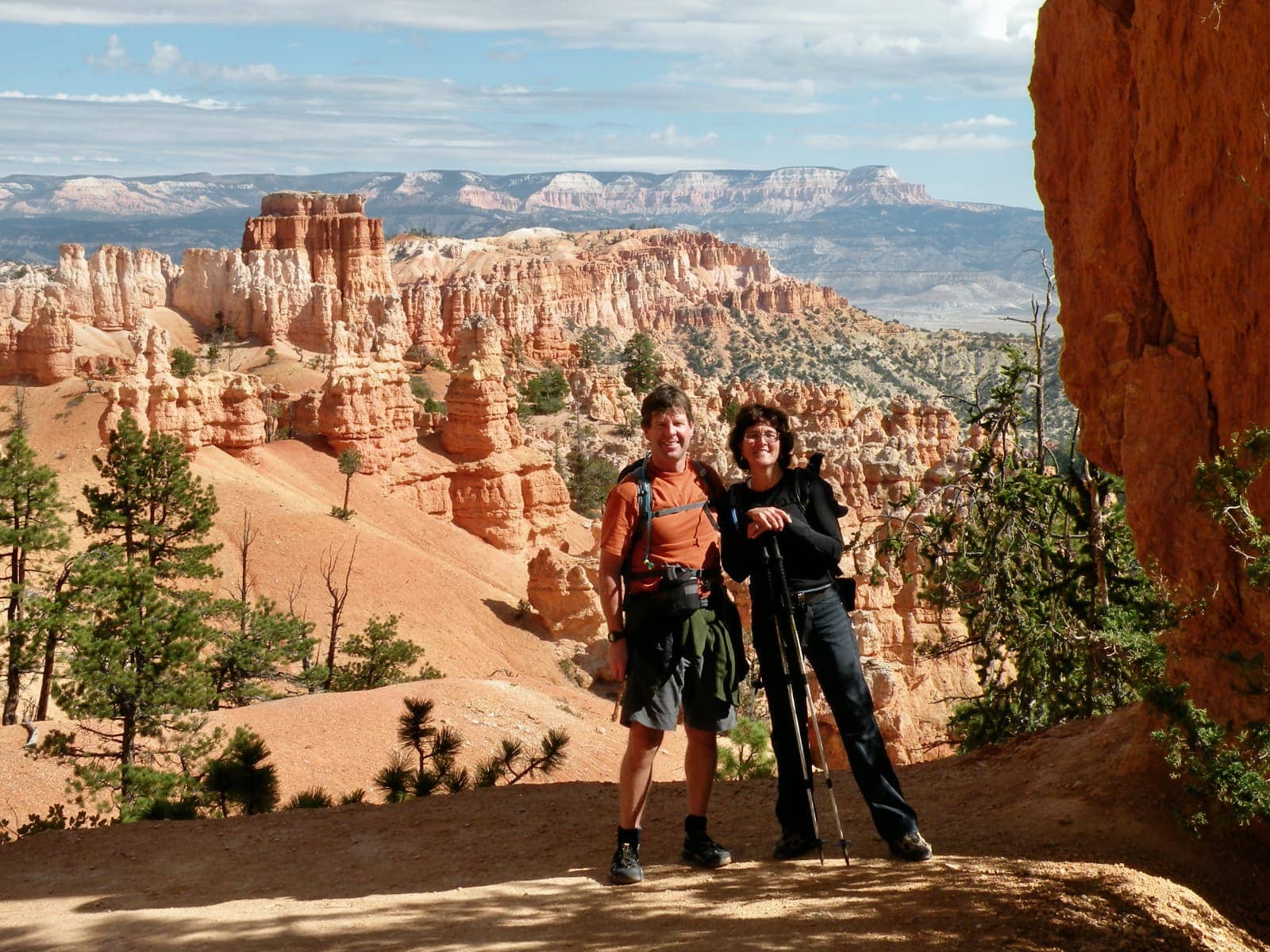 Man and woman posing with unique rock formations in background