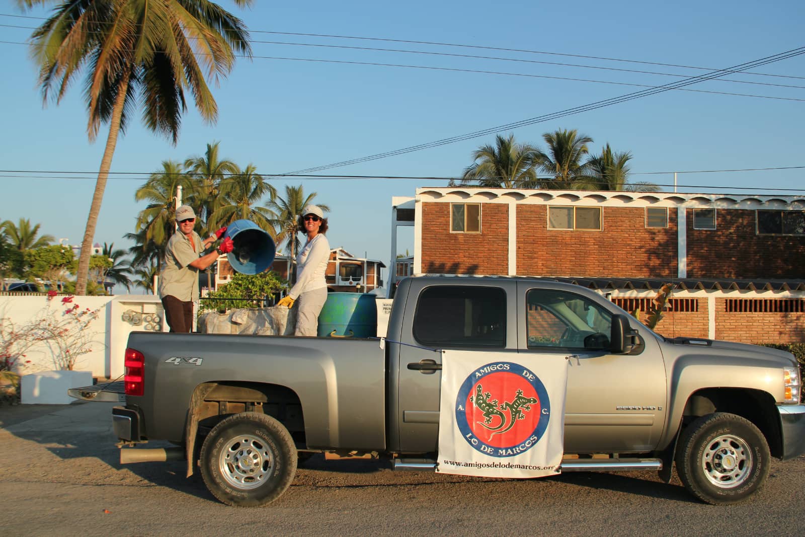 Man and woman standing in back of pickup truck