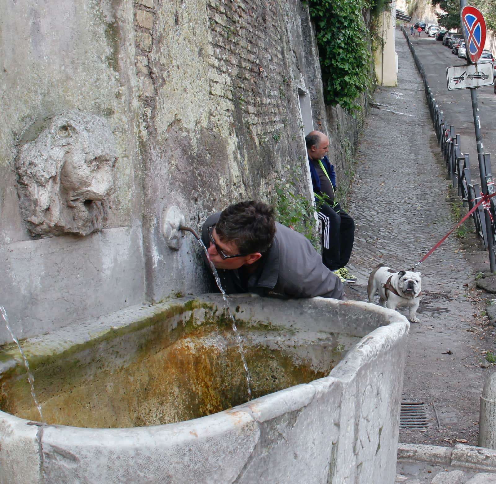 Man drinking from water fountain