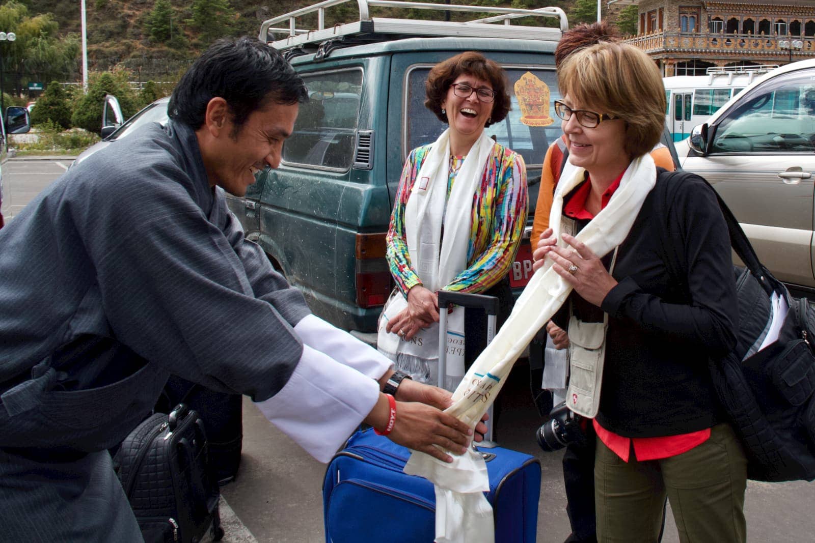 Man helping woman with white scarf