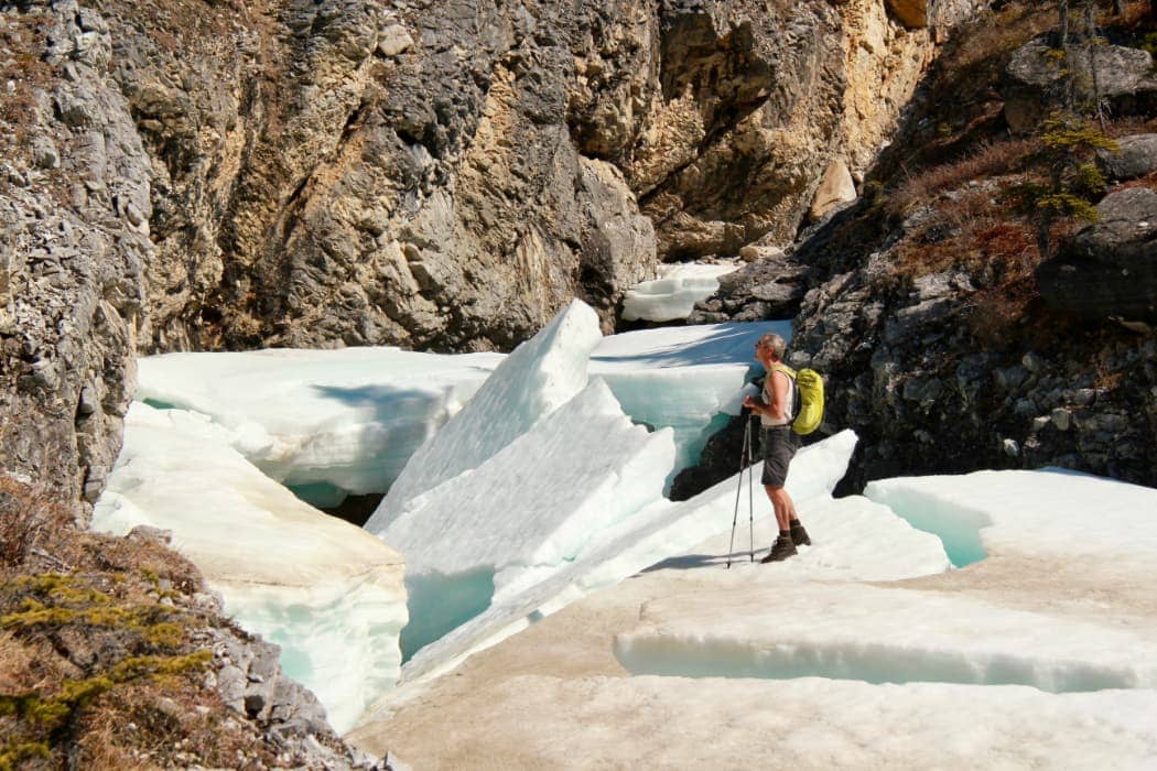 Man hiking in canyon on large chunks of ice