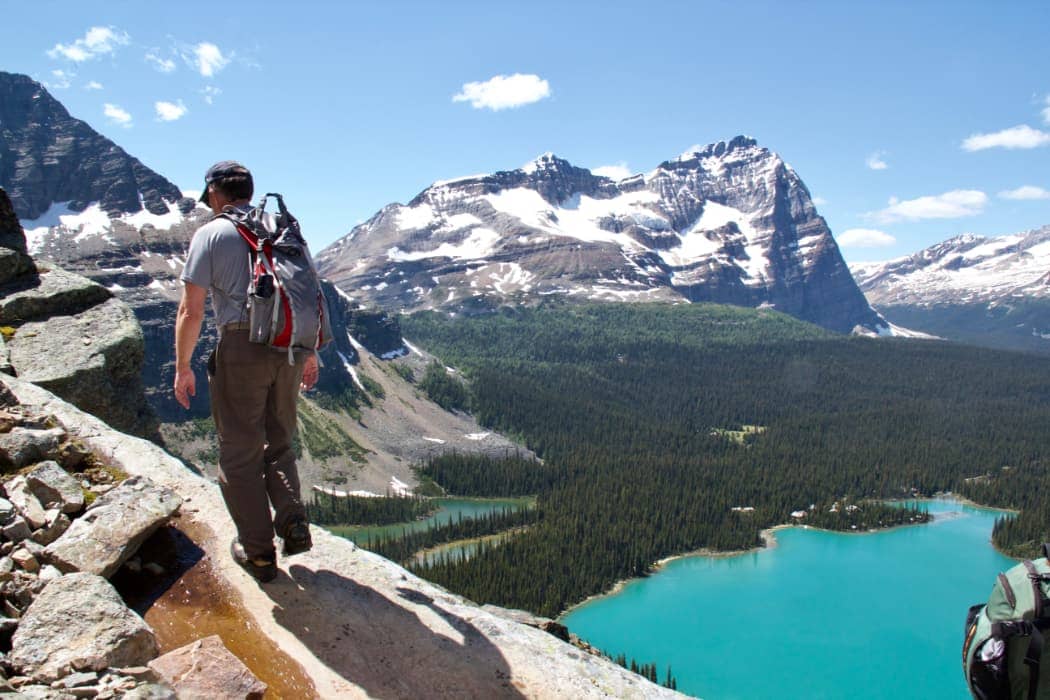 Man hiking with mountains and turquoise lake in background