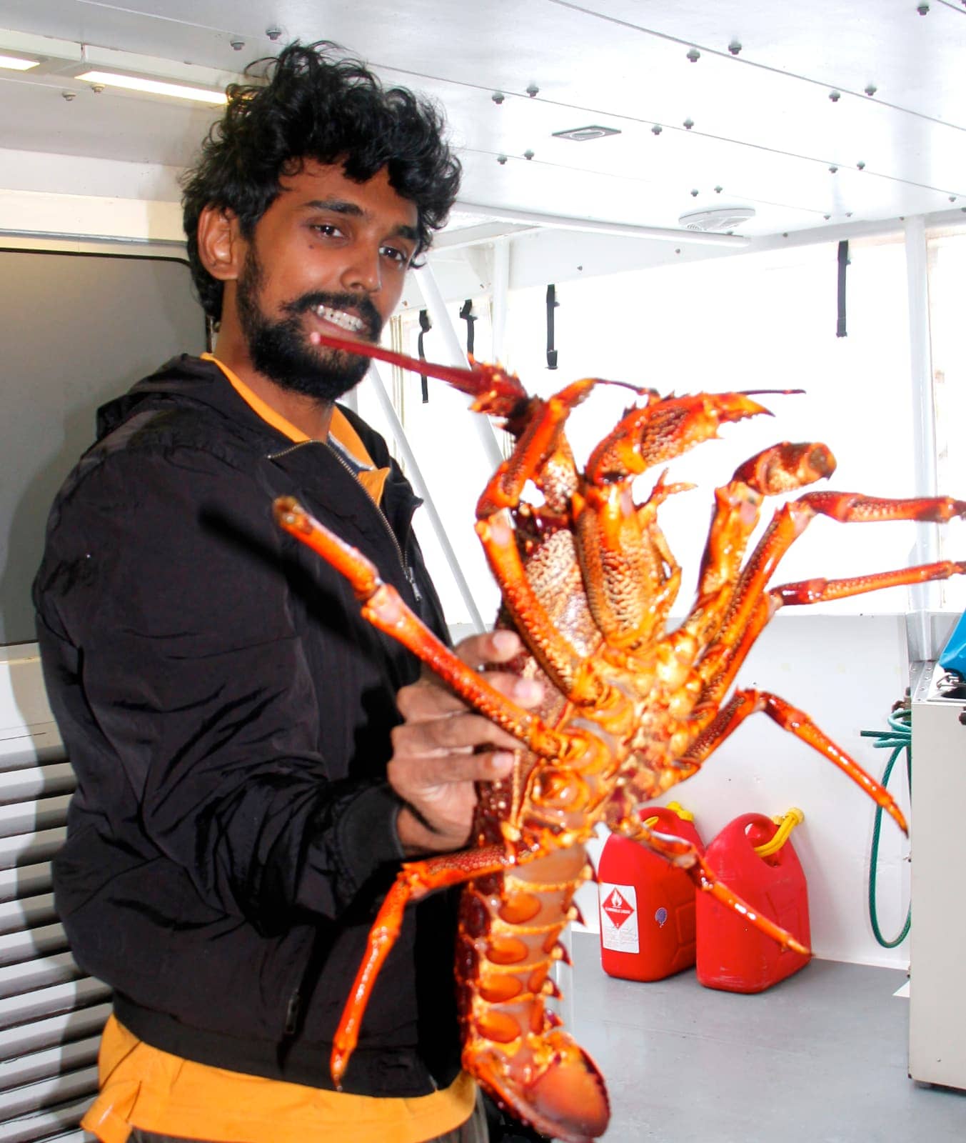 Man holding large orange crayfish