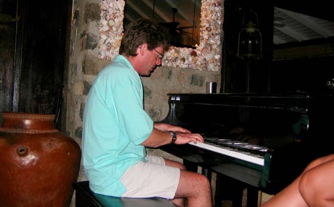 Man in blue shirt playing piano