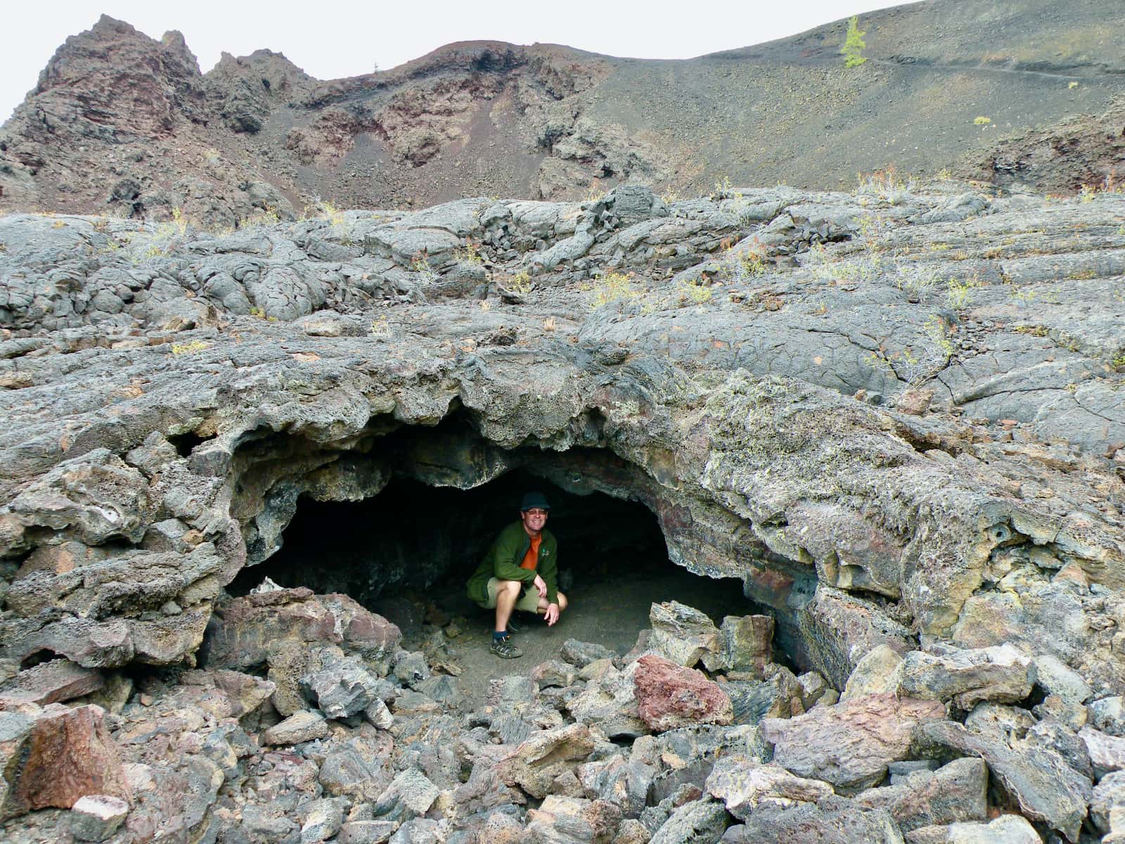 Man kneeling in small rock cave