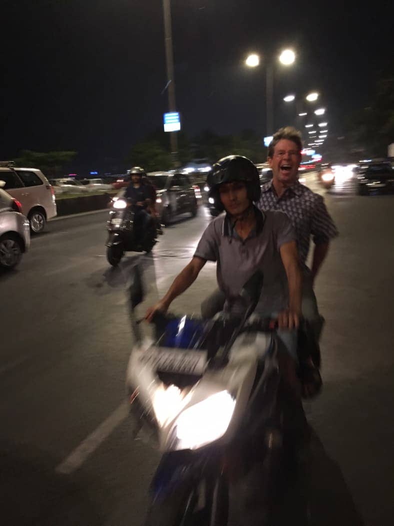Man laughing while riding on scooter