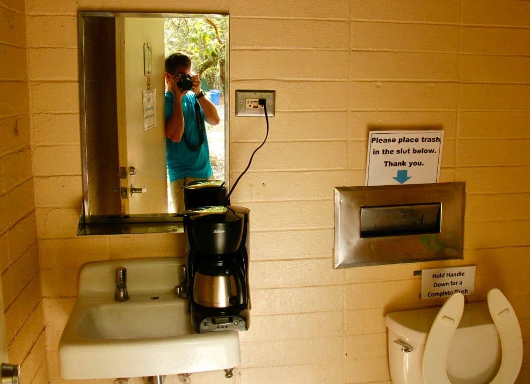 Man photographing coffee maker in public toilet