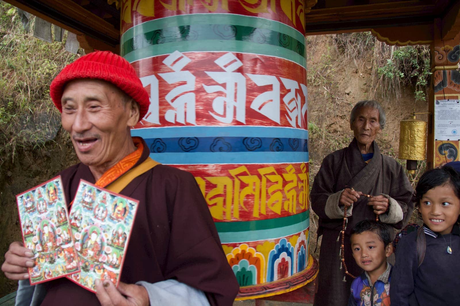 Man showing illustrations with two children and adult in background