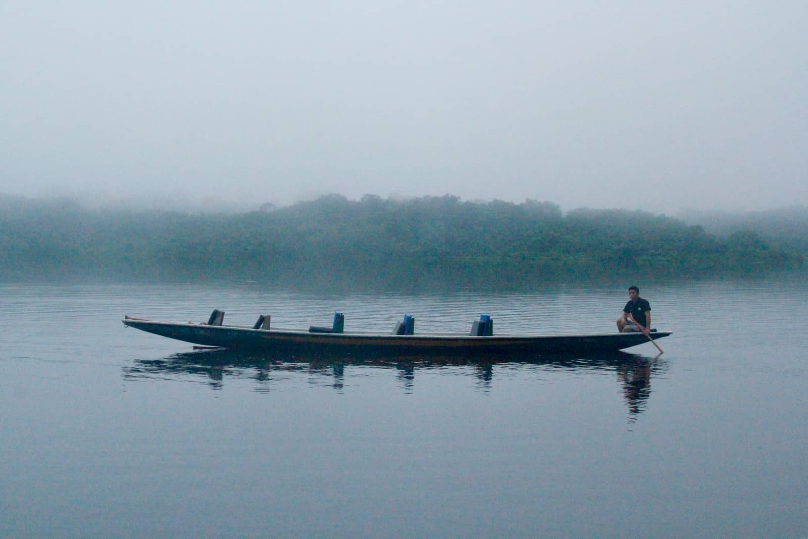 Man sitting in canoe on river