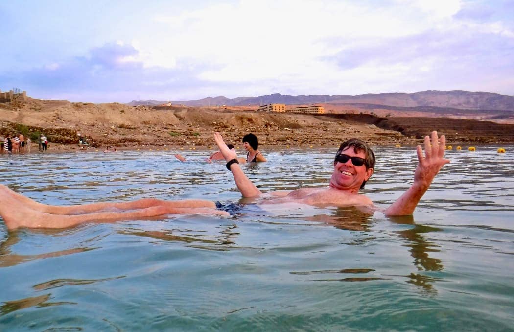 Man smiling and floating in Dead Sea in Jordan