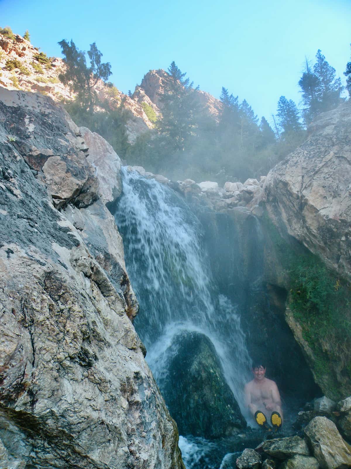 Man soaking in mountain rock pool