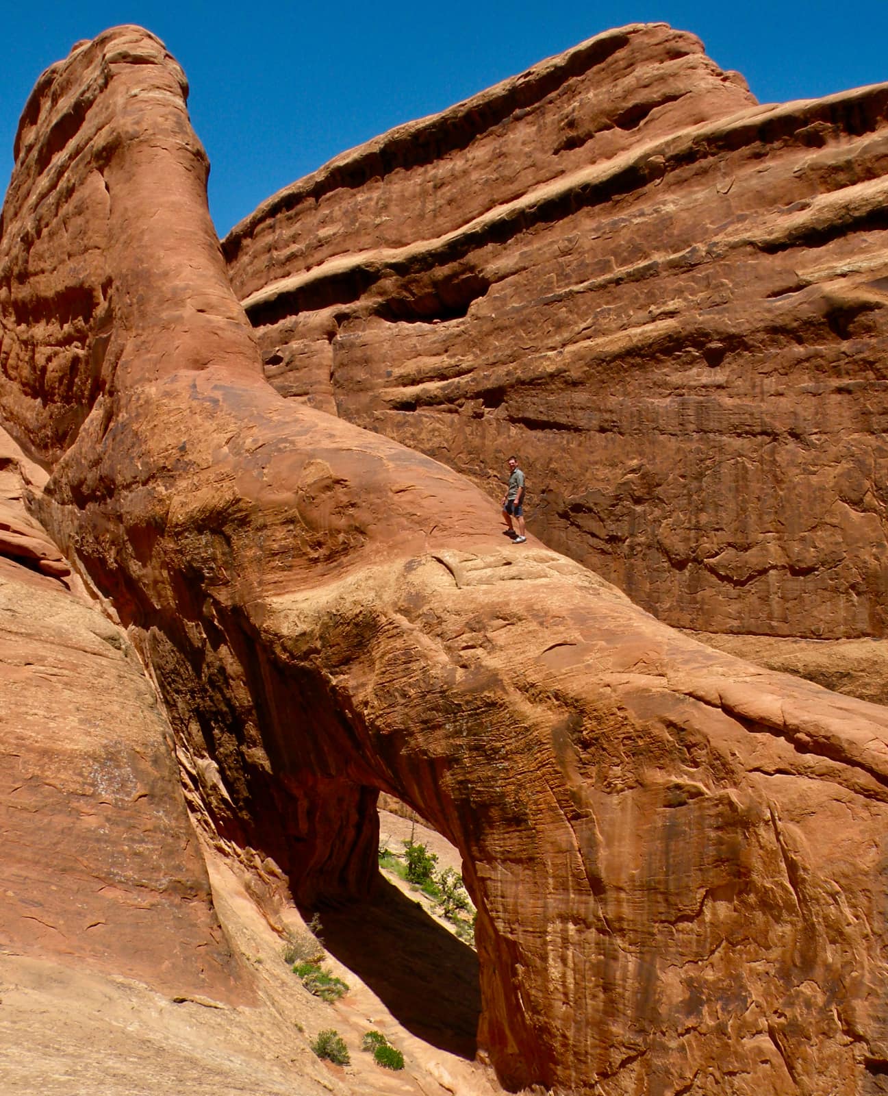 Man standing on enormous red rock formation