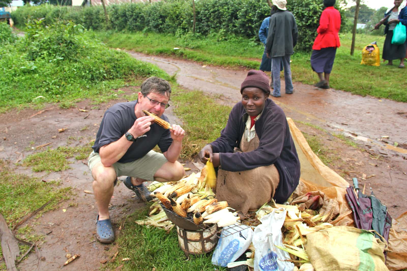 Man trying grilled corn from a roadside stand