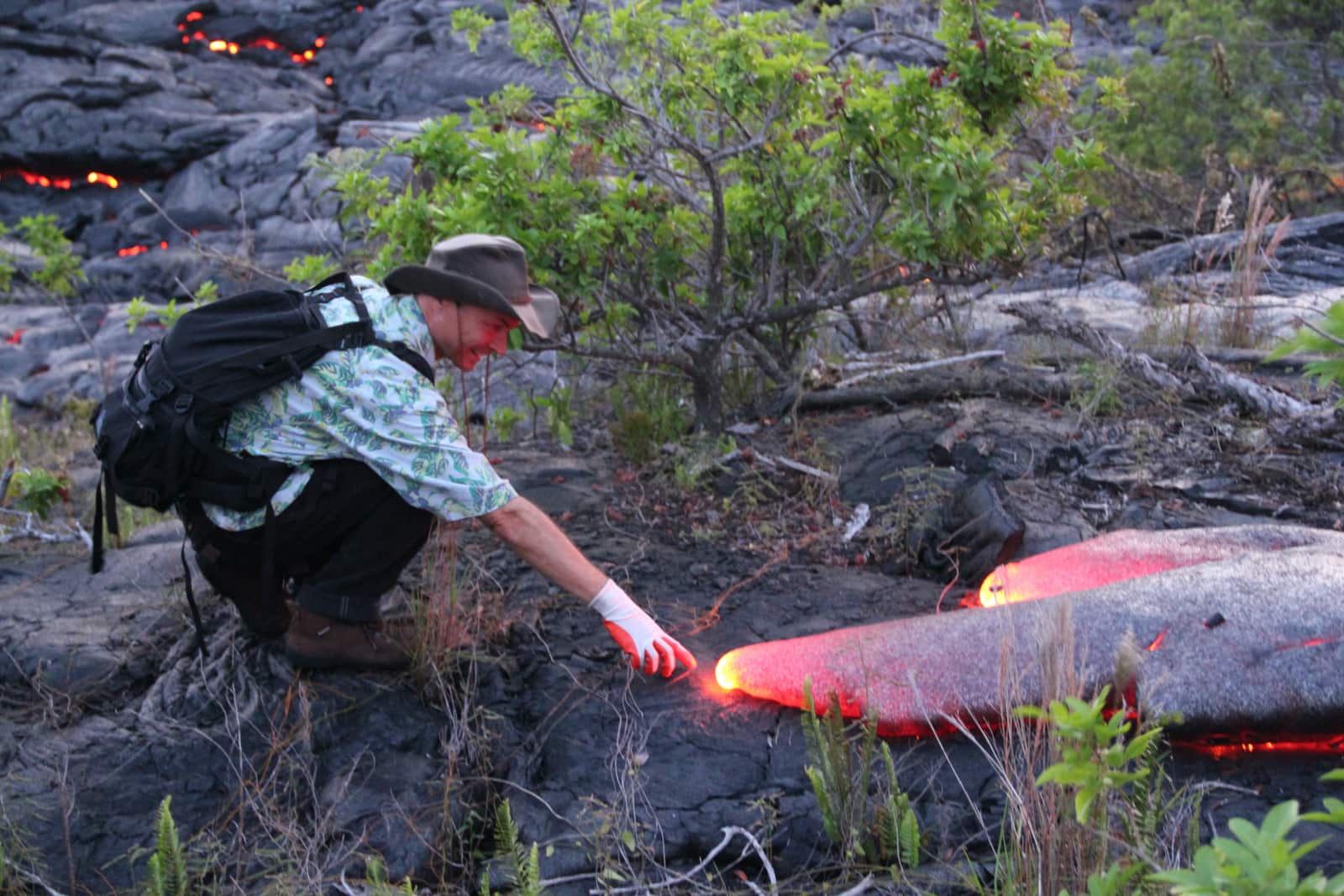 Man with glove on right hand reaching for hot lava