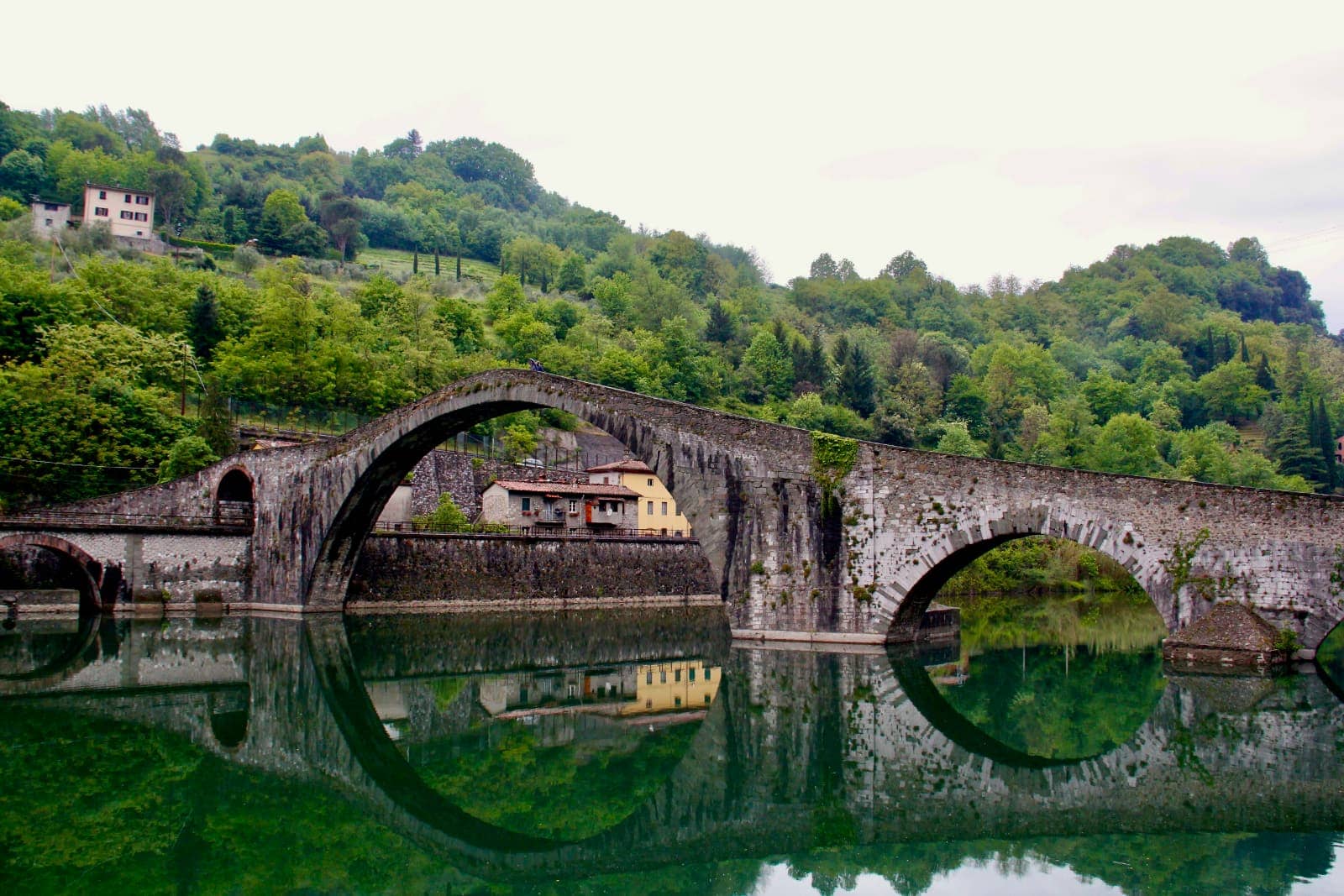 Old stone arch bridge over reflective water