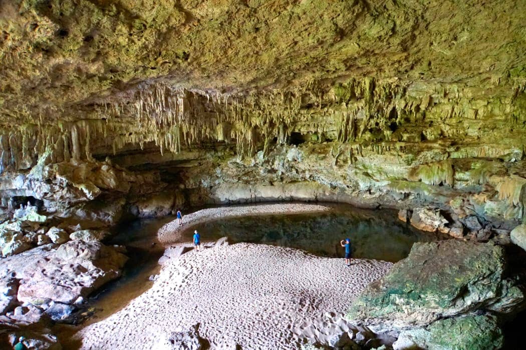 People exploring large cave